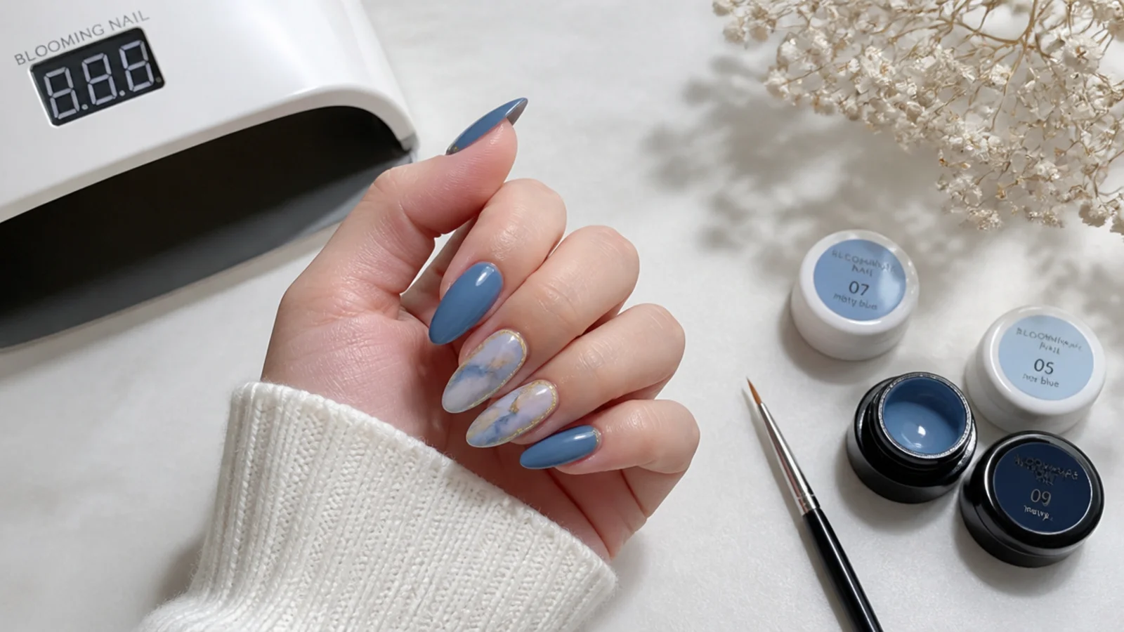 Flat lay of blooming gel, blue gel colors, a lamp and a detail brush