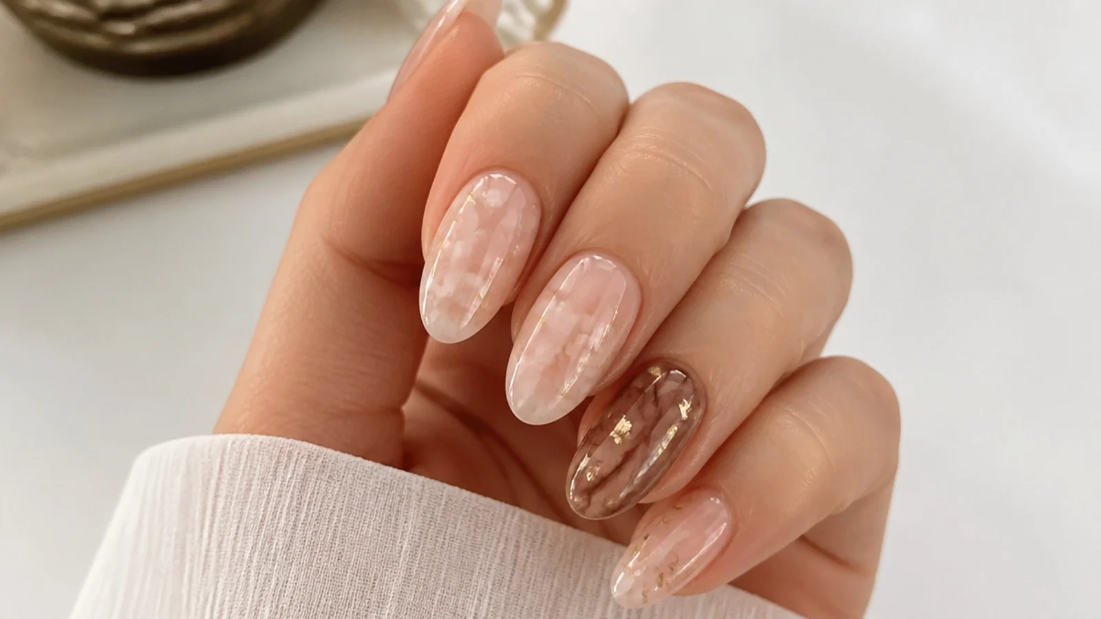 Nude blooming gel nails with one brown marbled accent nail