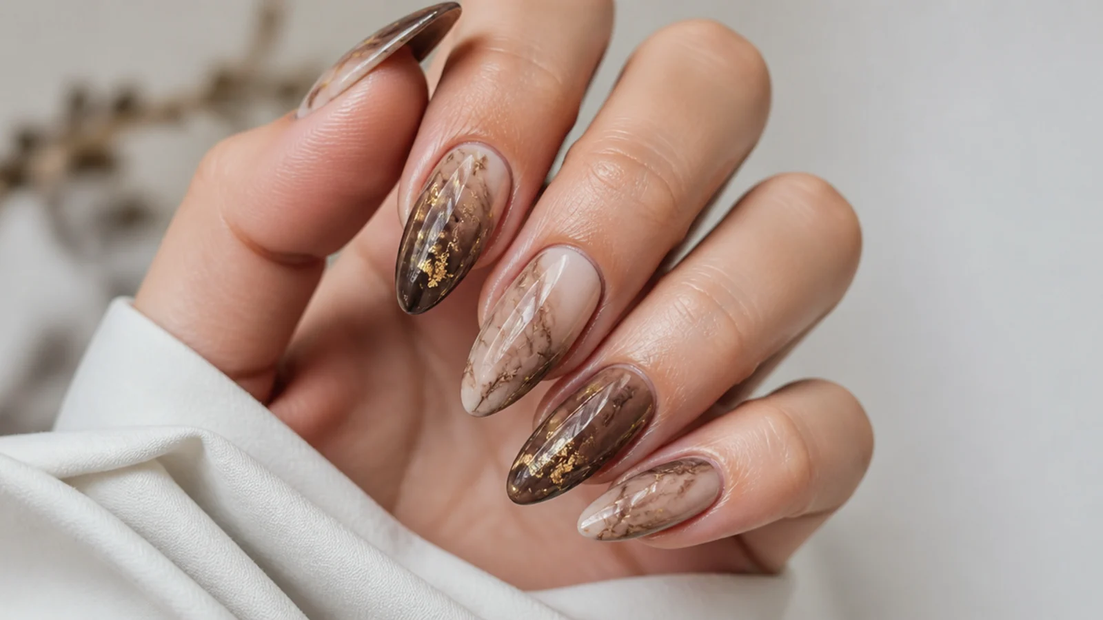 Mocha marble blooming gel nails with scattered gold flake accents