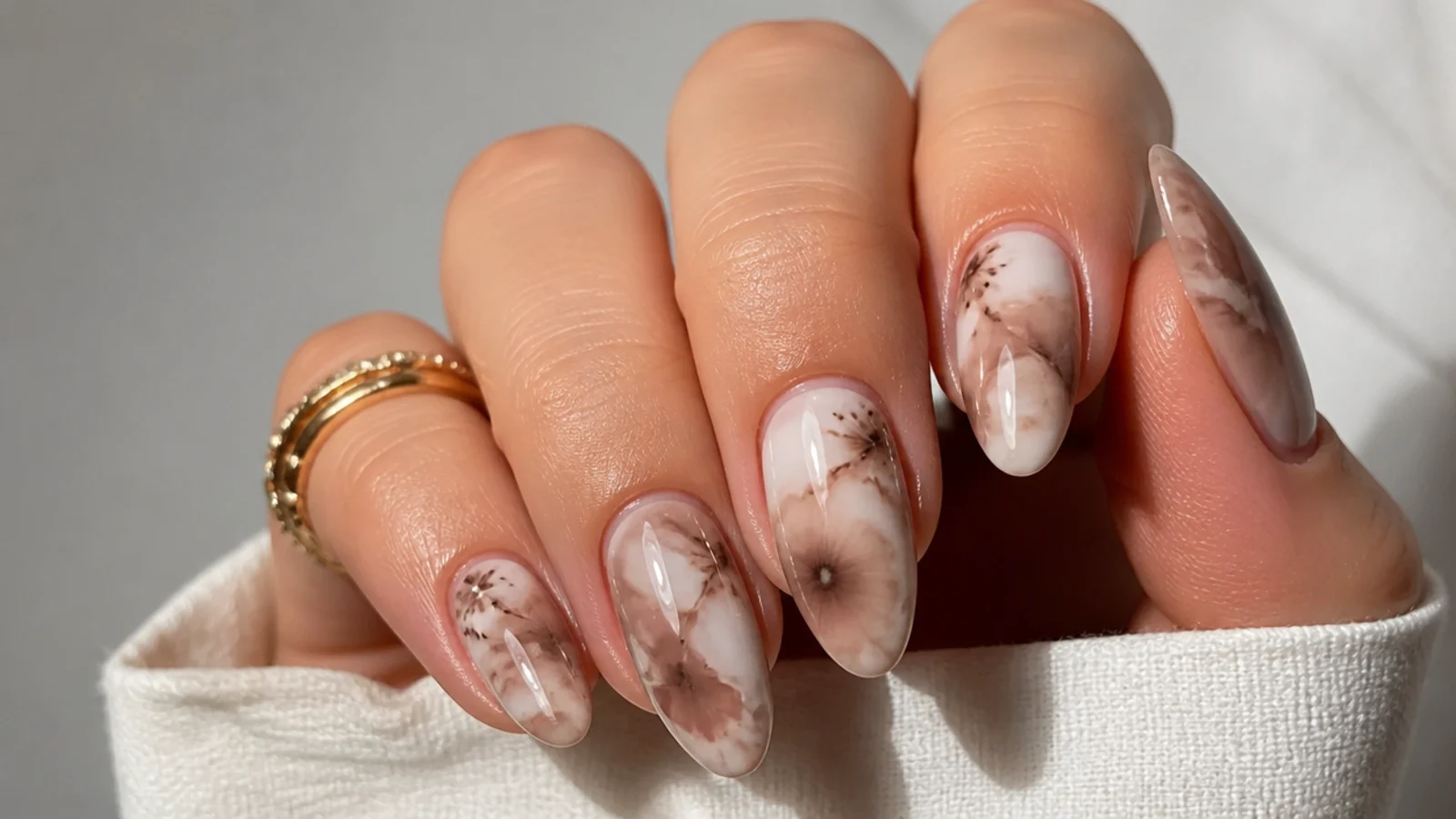 Mocha and cream brown blooming gel nails with a soft marbled pattern on an almond shape