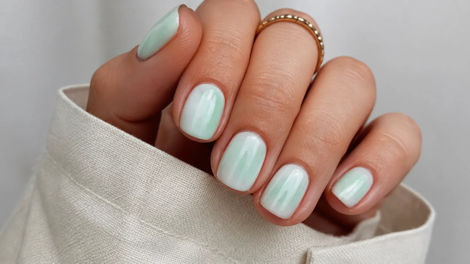 Pastel mint green tie-dye diffusion over a white base on short nails