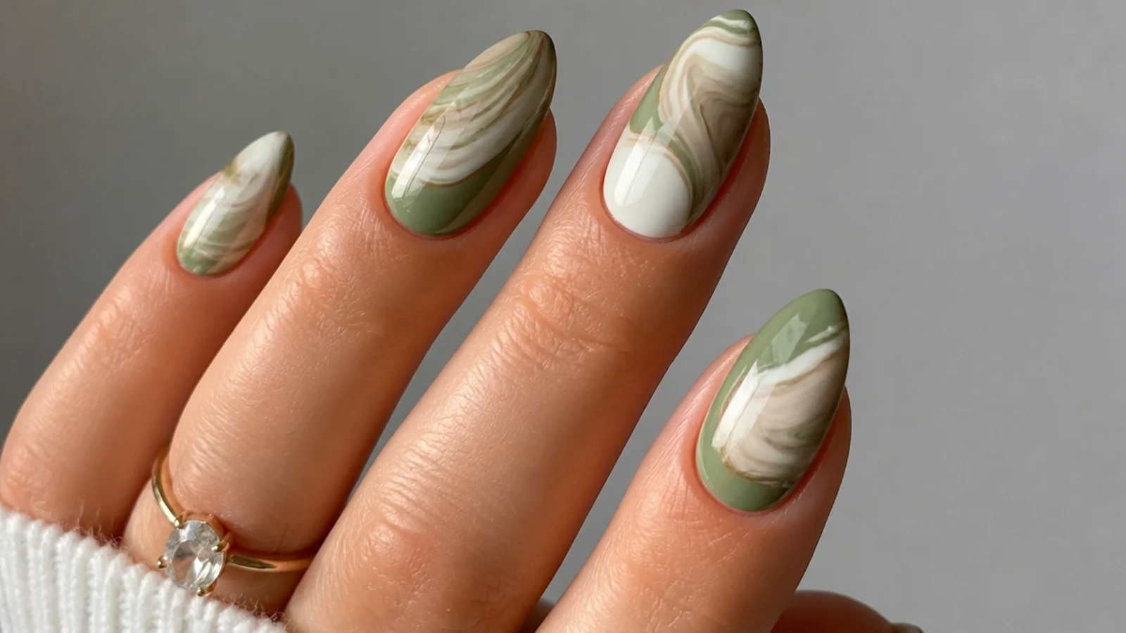 Muted matcha green and cream marble swirl on almond nails