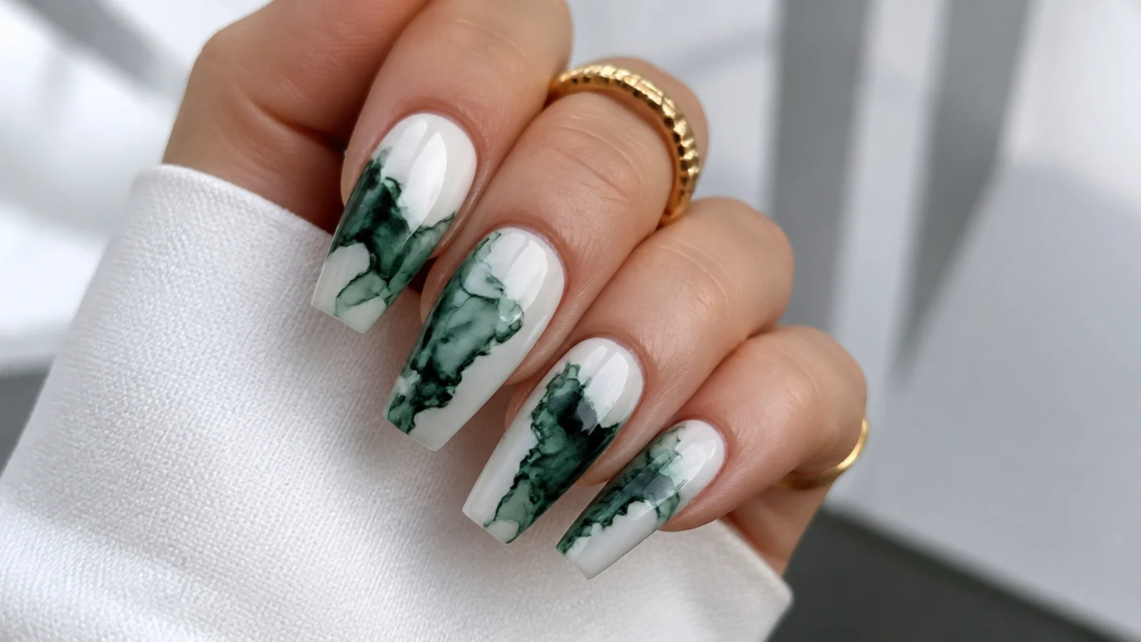 Dark green ink cloud diffusing across a white base on coffin nails