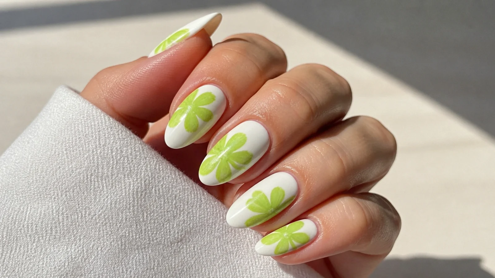 Bright neon lime green bloom over a white base on medium almond nails