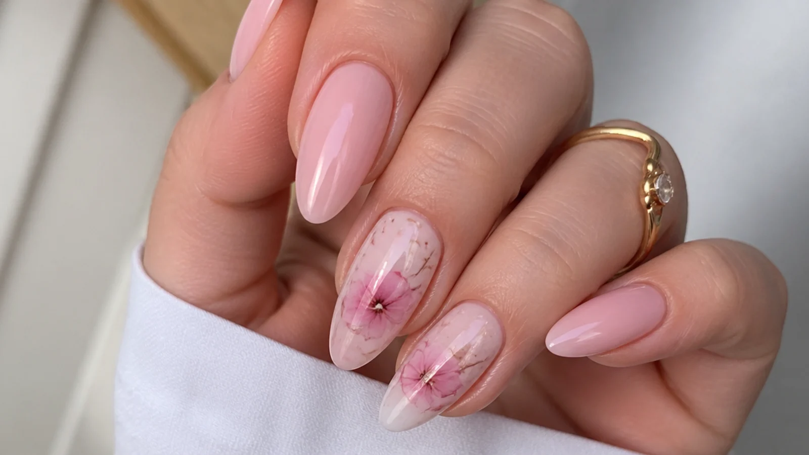 Soft pink blooming gel nails with a watercolor floral bloom on almond shapes
