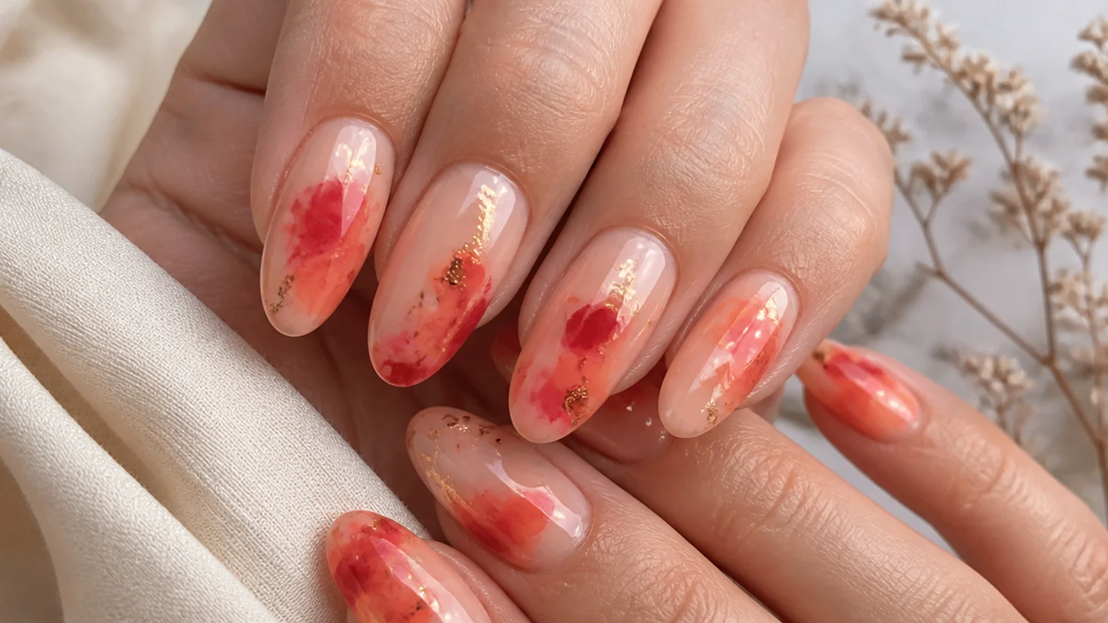 Coral to red watercolor blooming gel nails with a warm wash