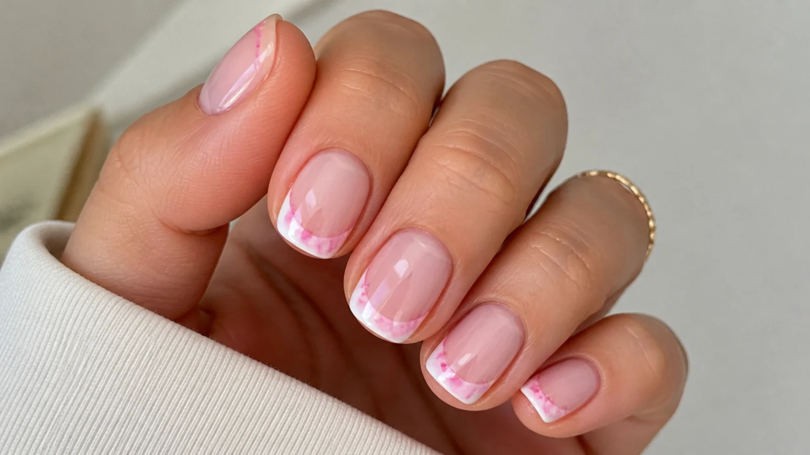 Short nails with a soft blooming gel French tip in pink and white