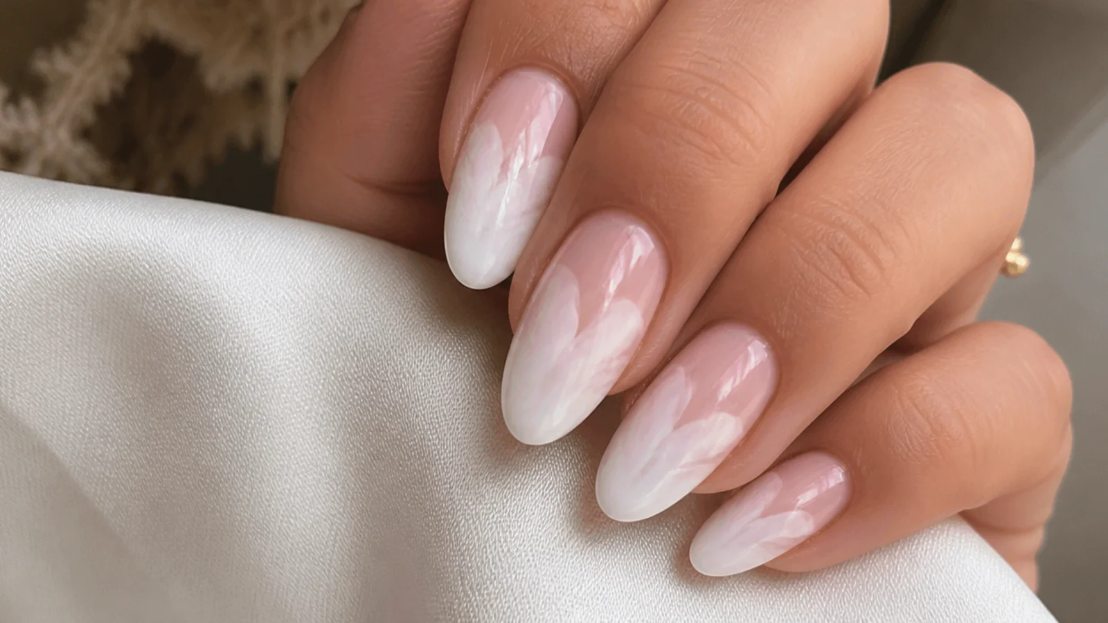 Close-up of white gel diffusing into a soft bloom on a nail