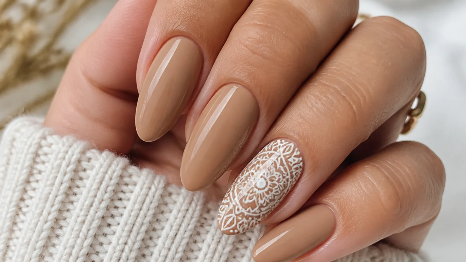 Tan nails with an opaque cream mandala on one accent nail