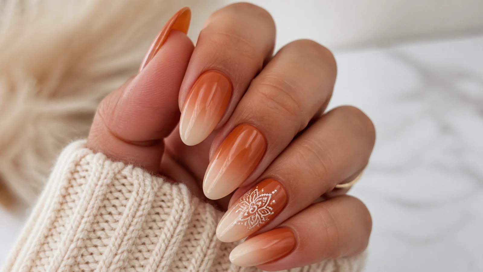 Terracotta-to-cream ombre nails with a cream mandala on the accent nail