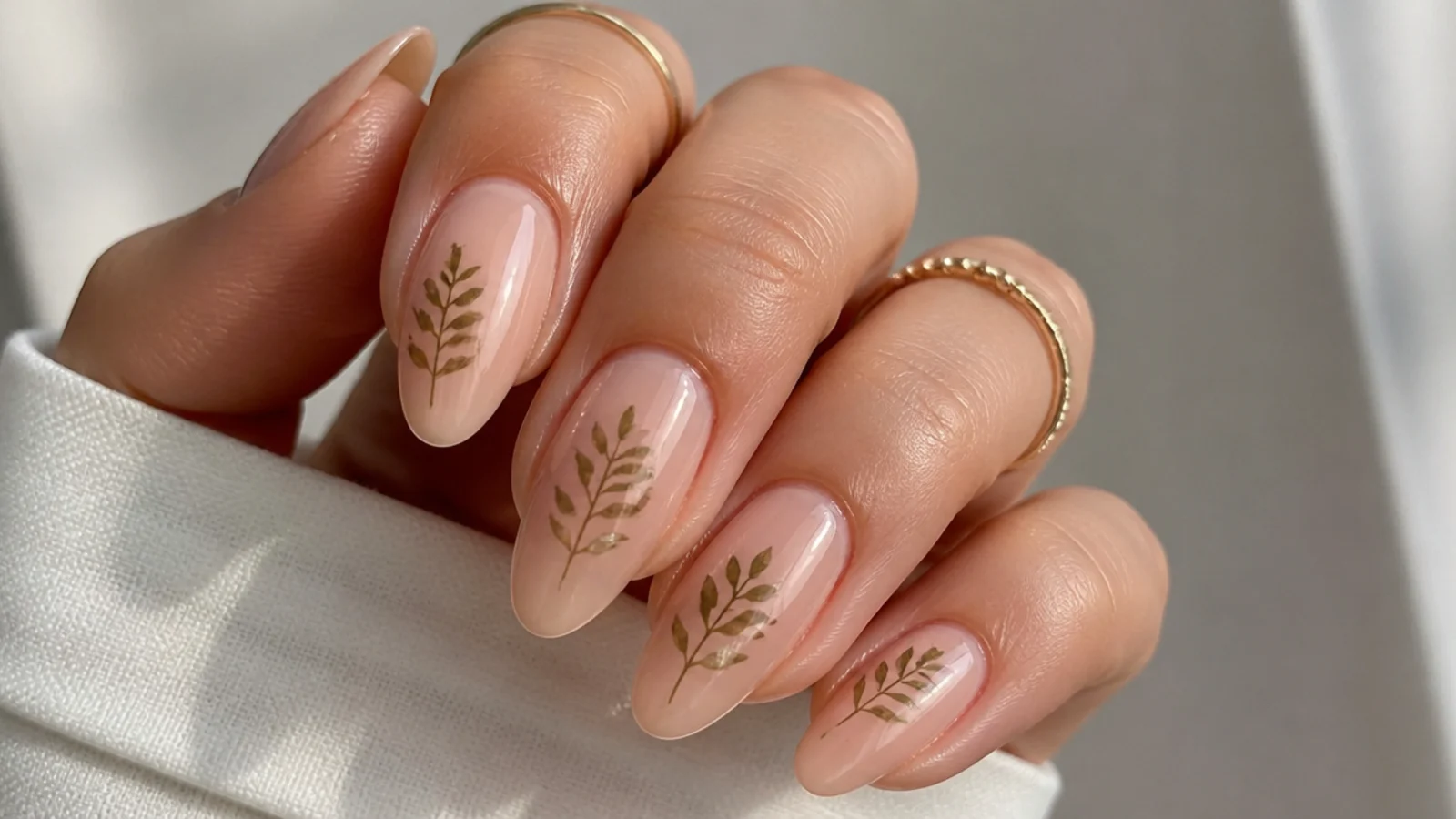 Sheer nude boho nails with delicate olive pressed-fern silhouettes