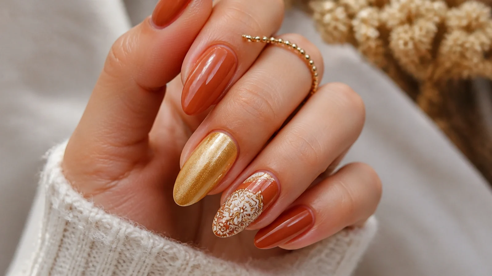 Warm terracotta and muted gold boho nails with a mandala accent on an almond shape