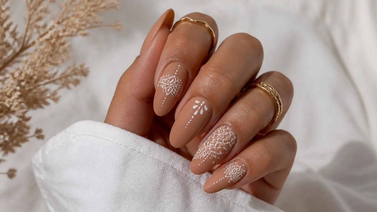 Tan boho nails with delicate white henna-style mandala patterns