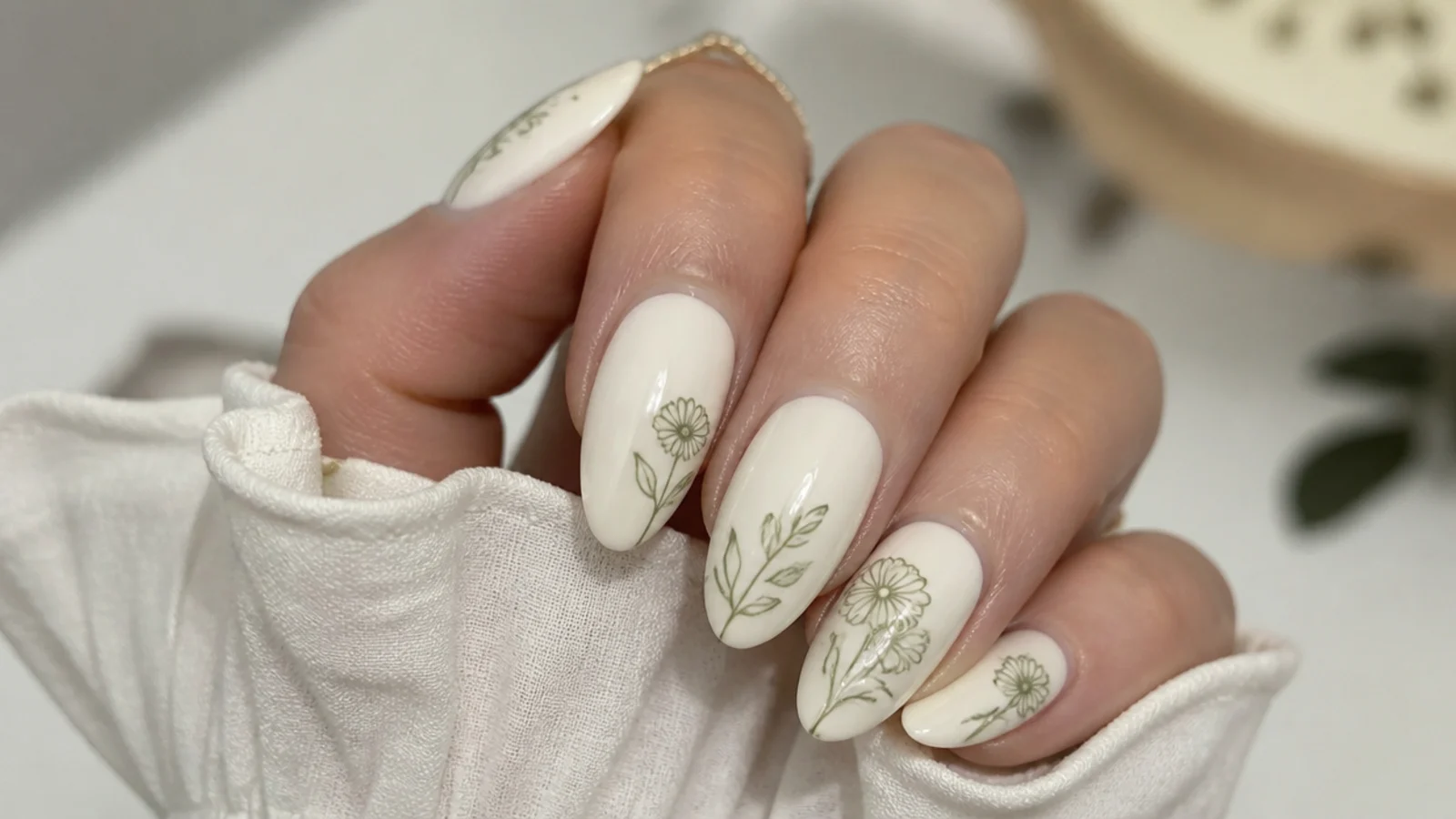 Cream boho nails with minimal sage green line-drawn flowers