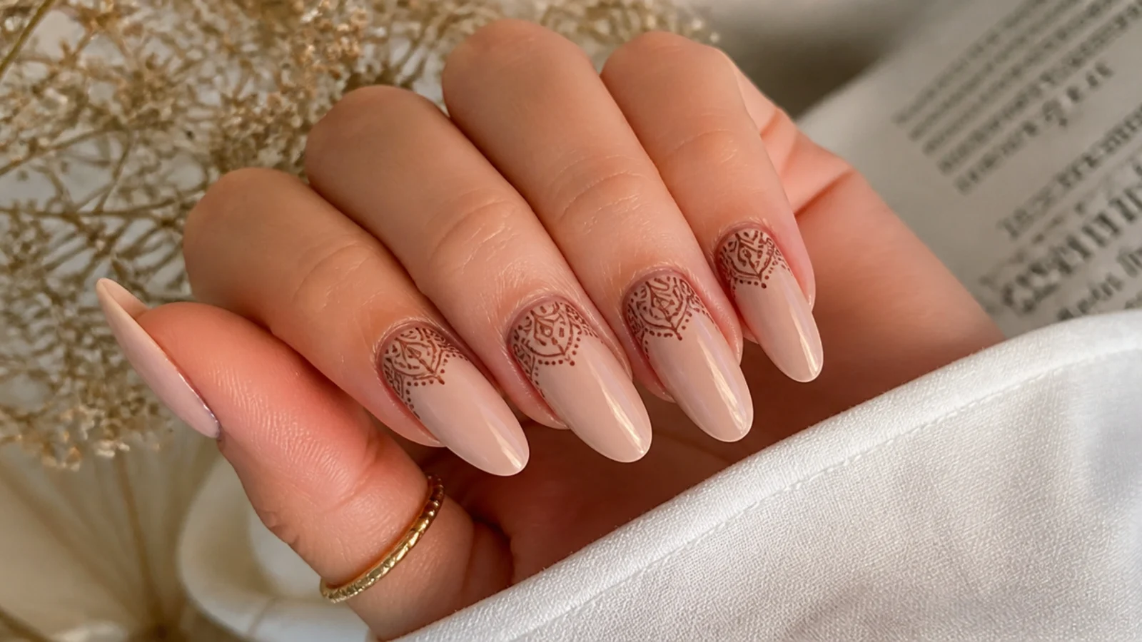 Nude boho wedding nails with fine brown henna-style paisley line art at the cuticle