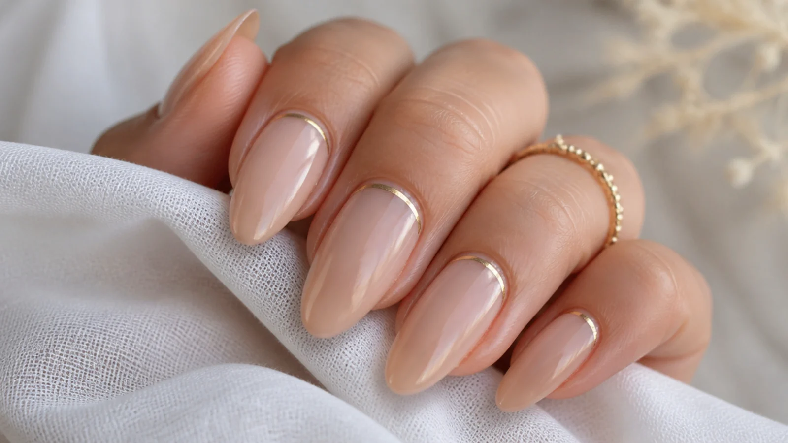 Sheer nude almond boho wedding nails with a thin gold cuff at the cuticle