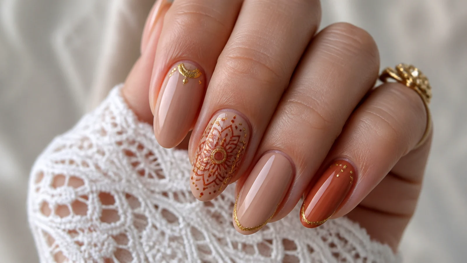 Warm nude boho wedding nails with a detailed rust and gold mandala accent
