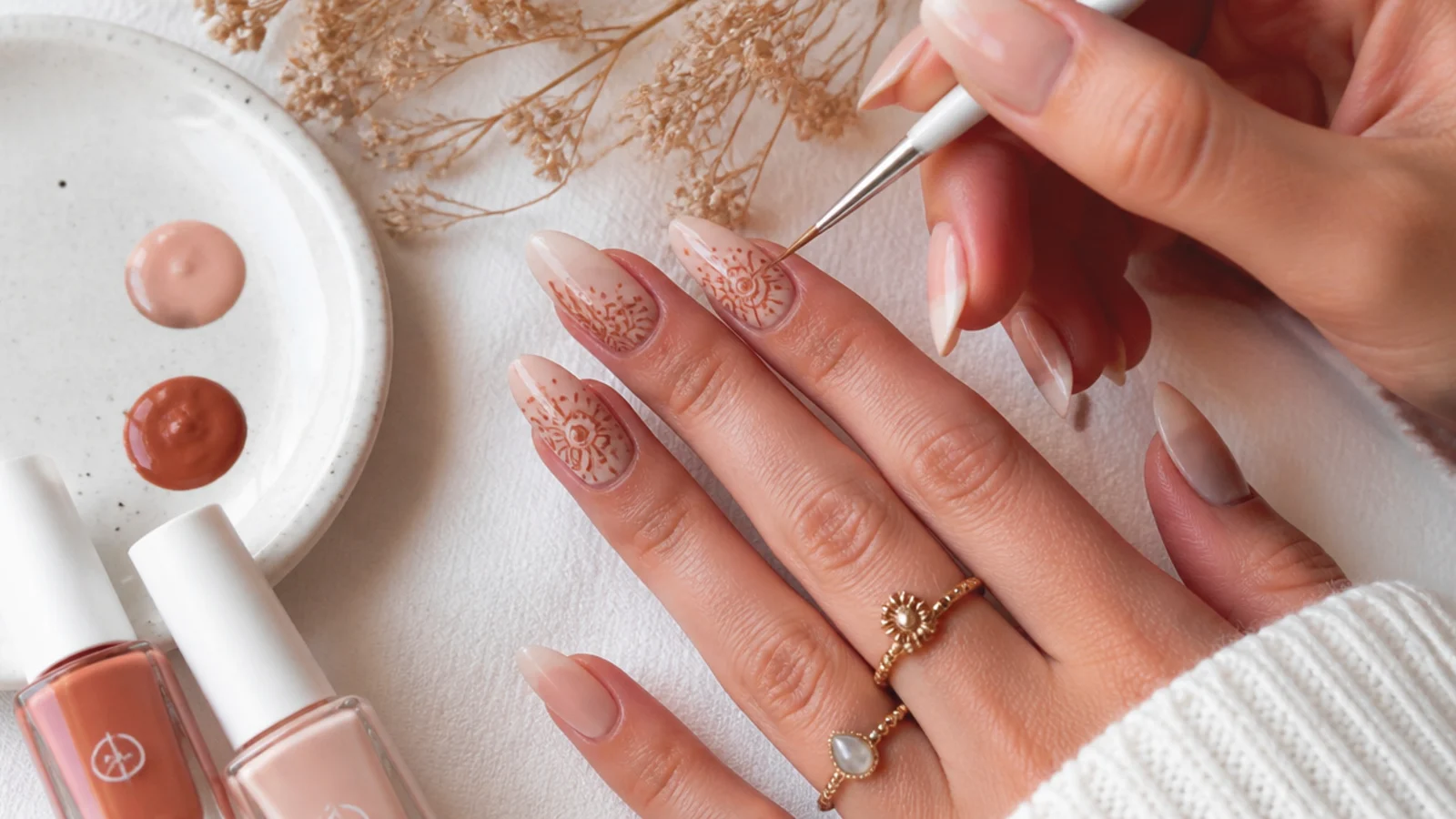 Boho nail supplies with a liner brush drawing a terracotta mandala at home