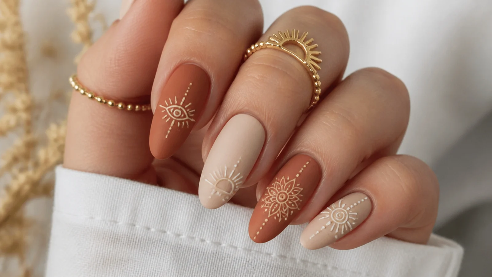 Earthy matte boho nails with imperfect hand-drawn mandala and sun motifs