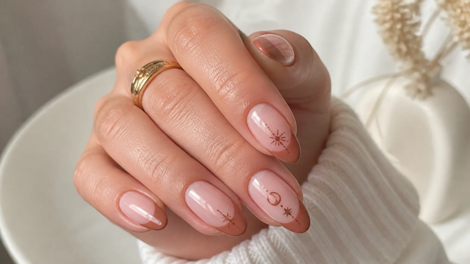 Warm brown French tip boho nails on a nude almond shape