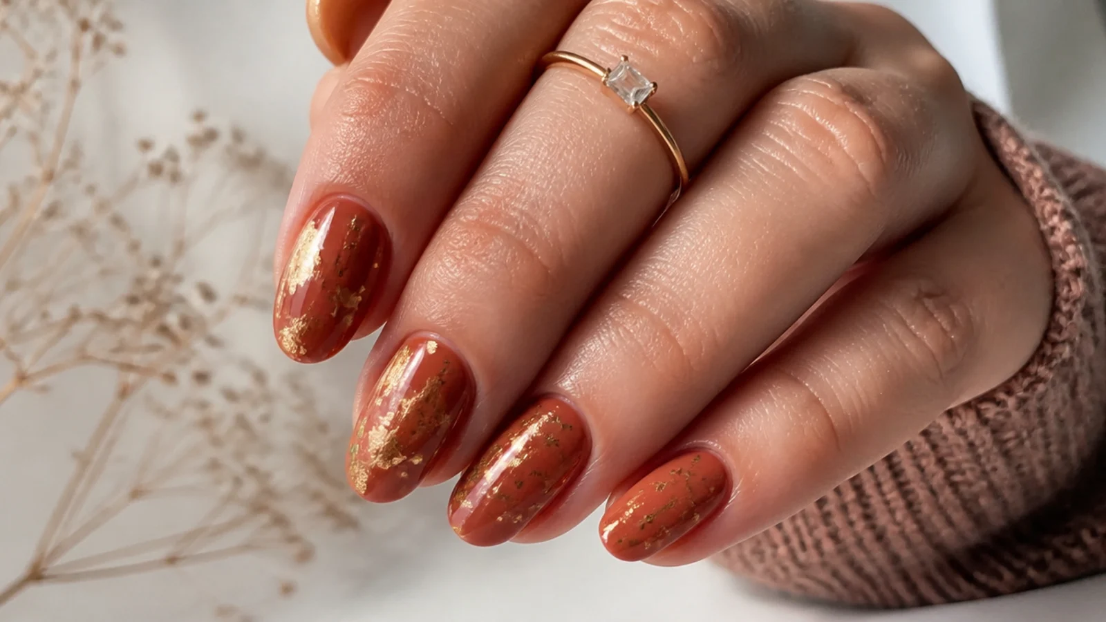 Muted gold foil flakes scattered over terracotta boho nails