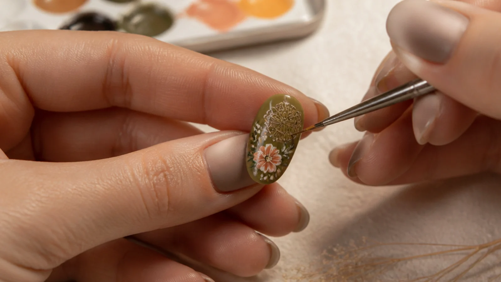 A thin liner brush painting loose florals and a fine mandala on an earthy nail