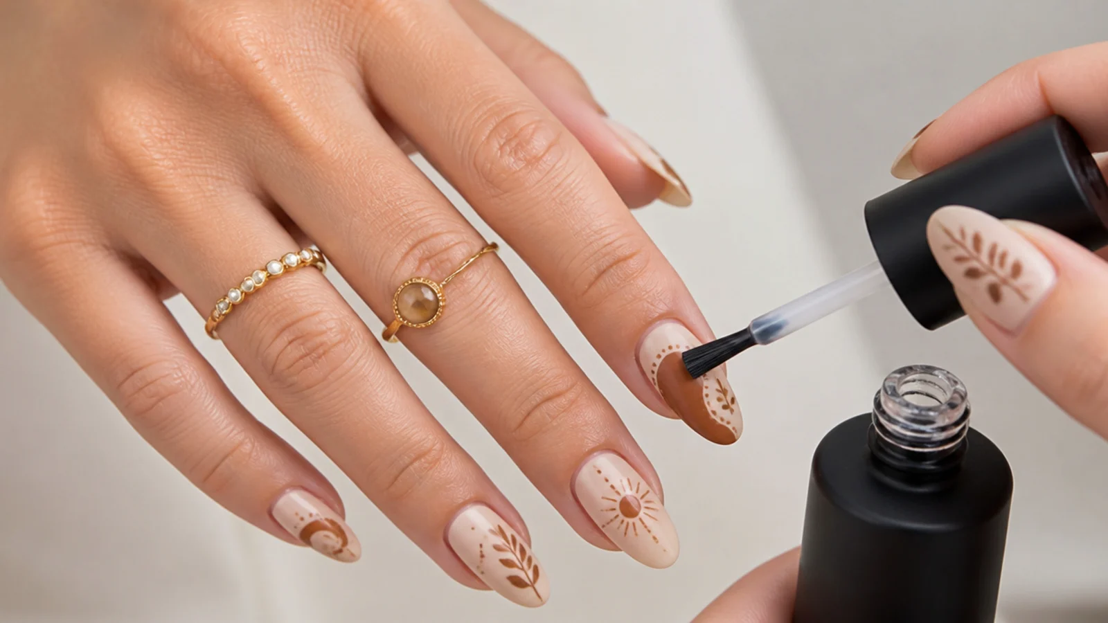 A matte gel top coat being brushed over finished earthy boho nails