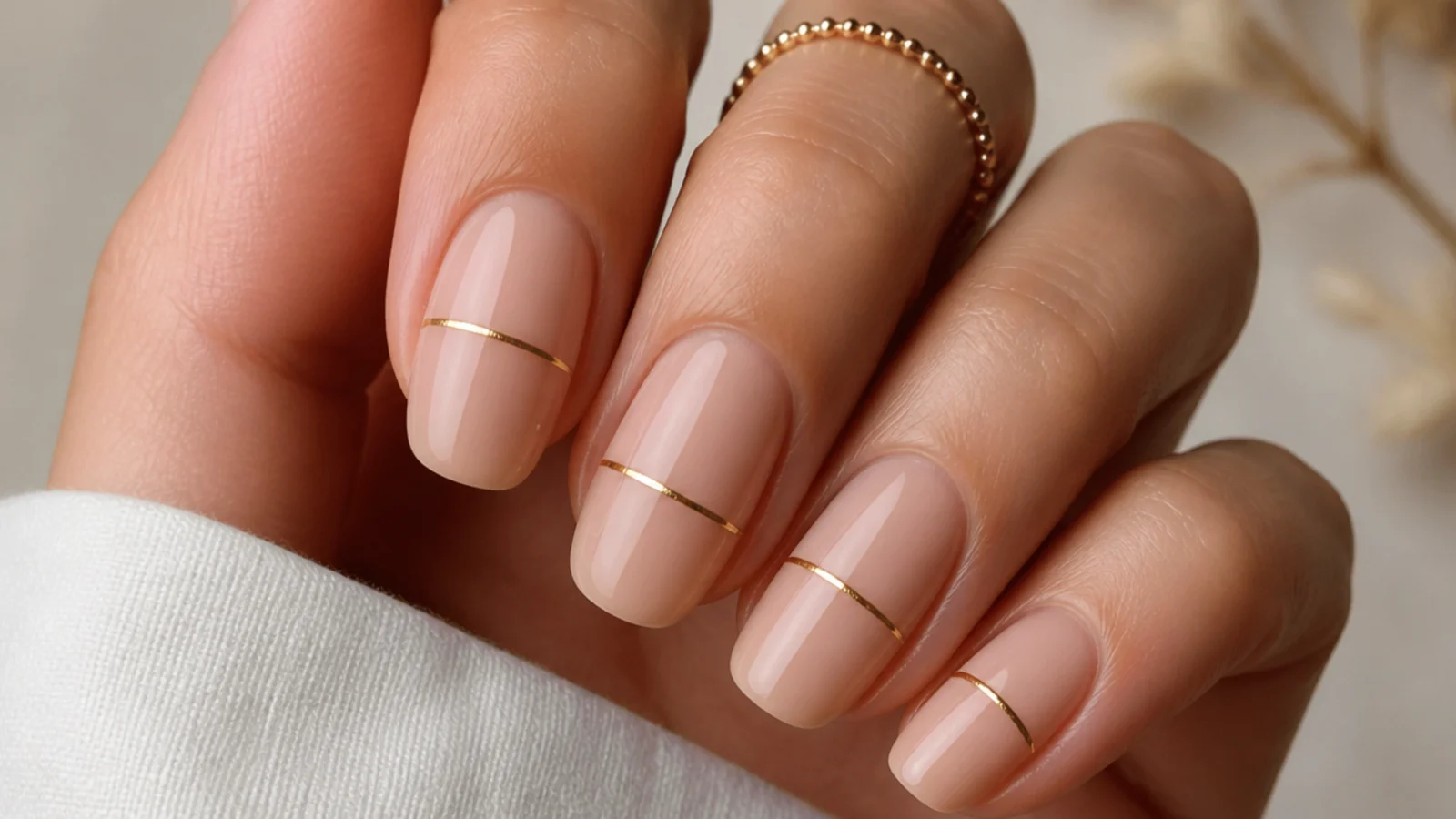 Nude boho nails with a single thin muted gold line across each nail