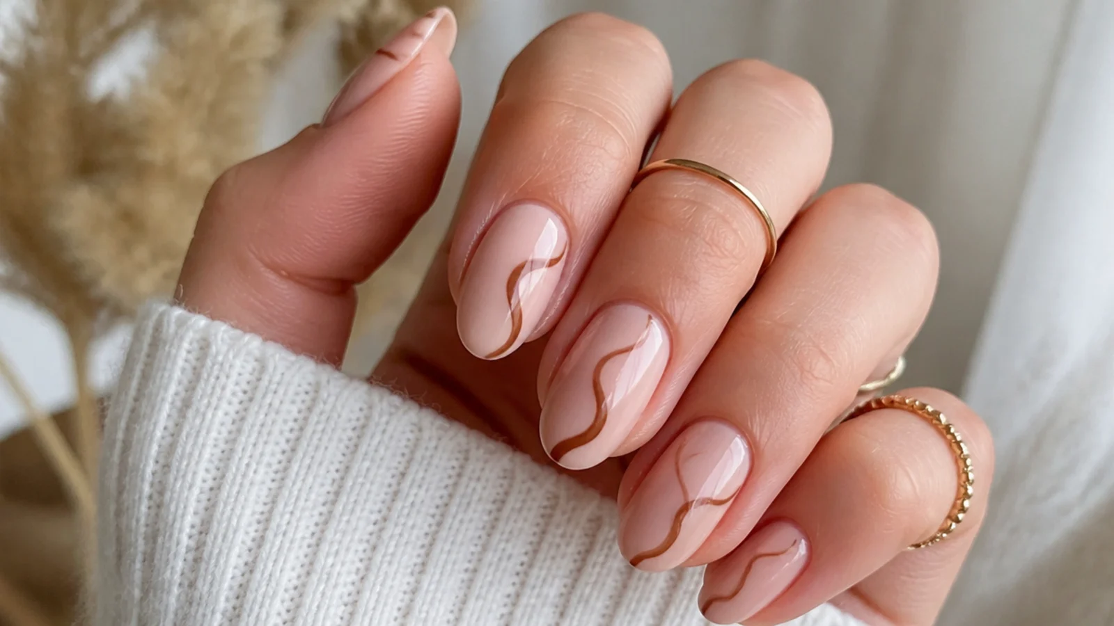 Nude boho nails with a single thin brown 70s swirl on each nail