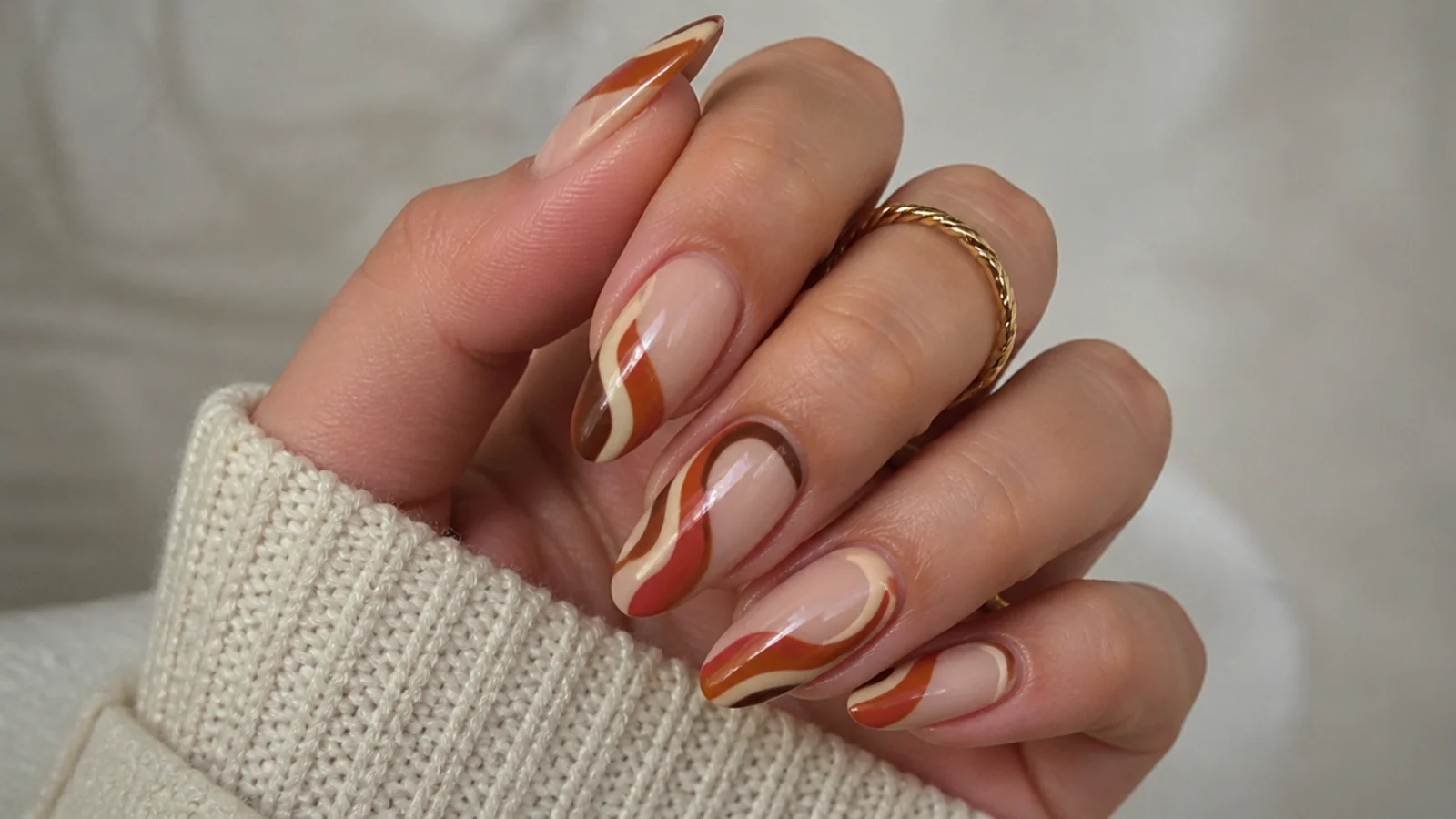 Rust and cream 70s swirl boho nails on an almond shape