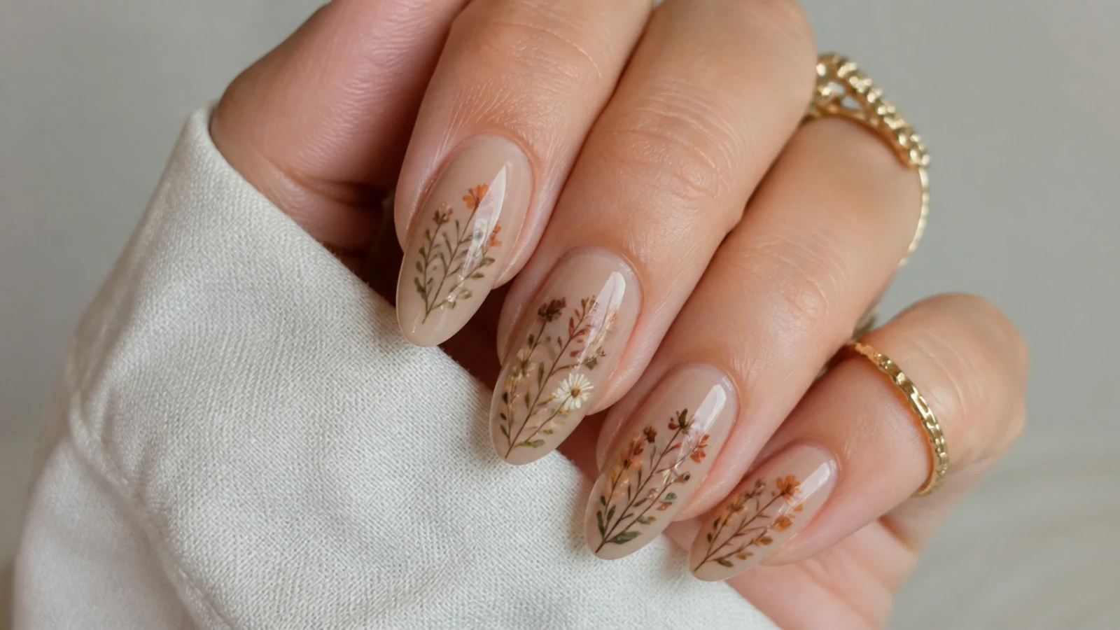 Boho nails with small muted wildflowers in rust, sage and cream on a tan base