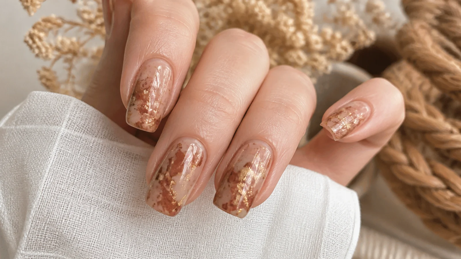 Boho nails in tan with muted gold foil flakes scattered like earthy marble