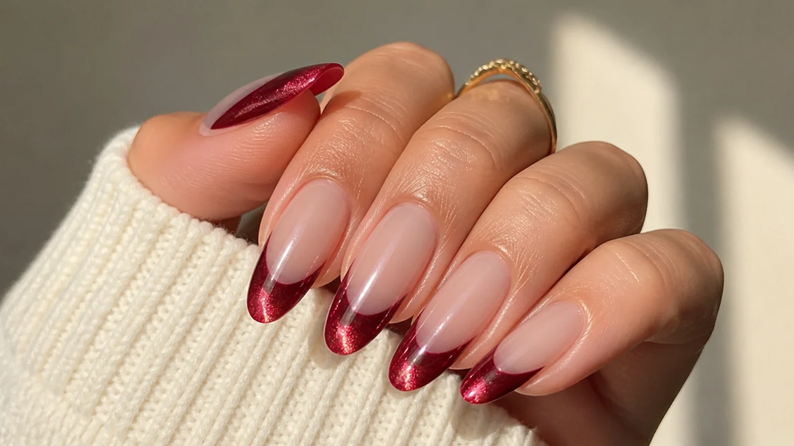 Almond nails with a glossy red magnetic cat eye french tip