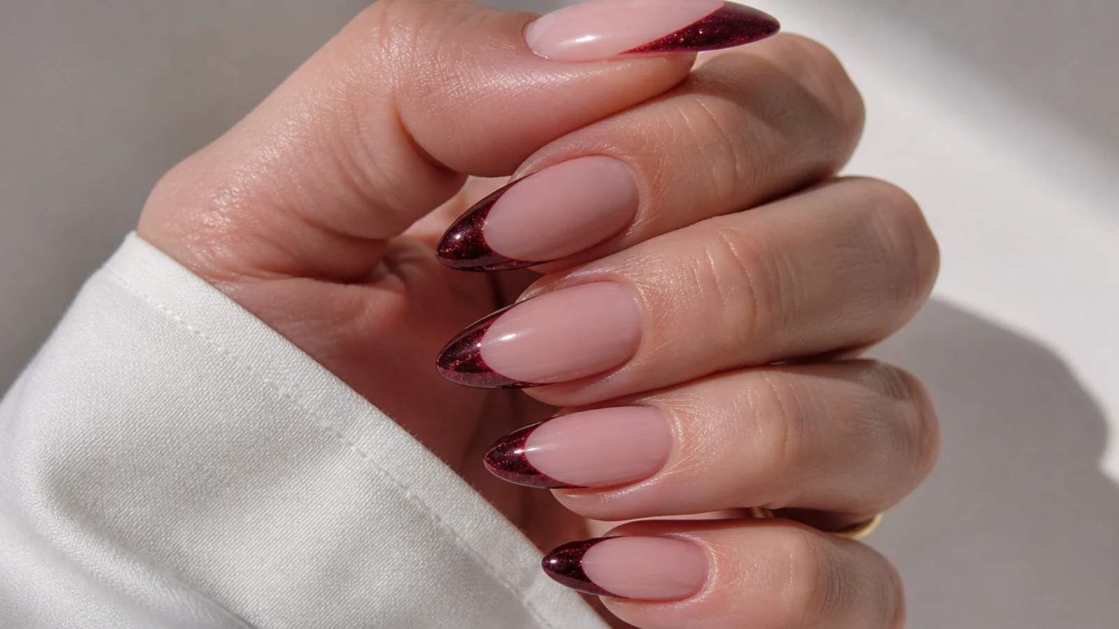 Almond nails with a deep burgundy magnetic cat eye french tip