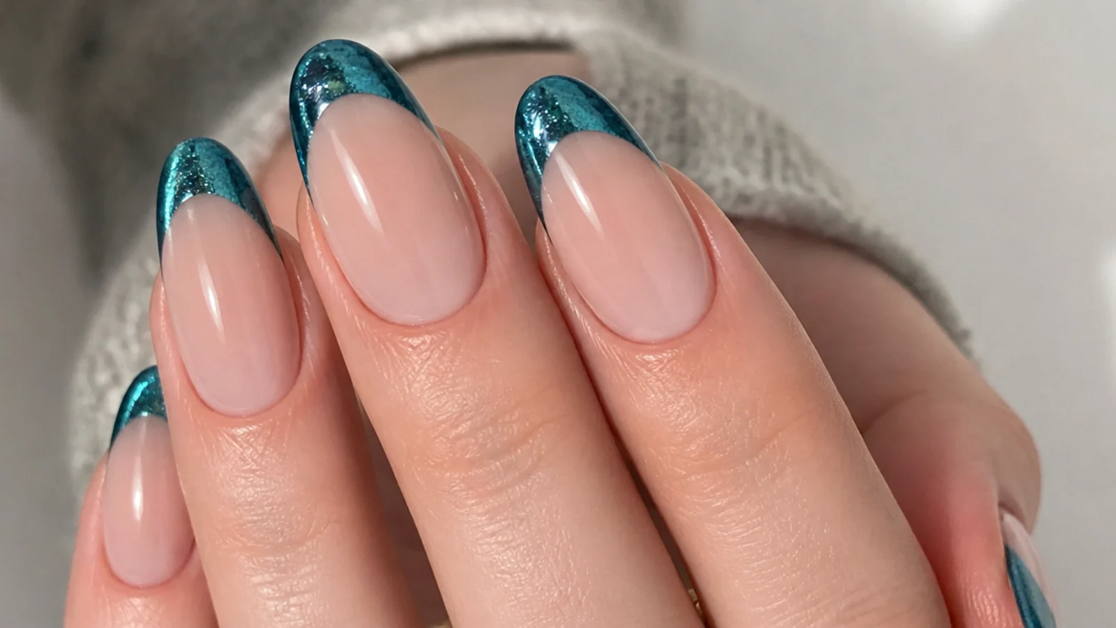 Almond nails with a teal magnetic cat eye french tip