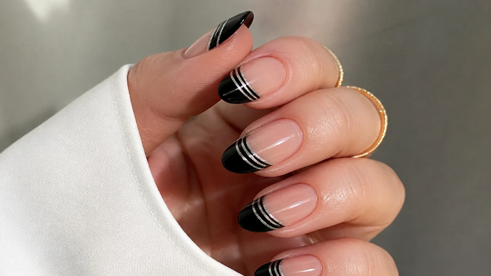 Black french tip nails with two parallel cat eye light stripes