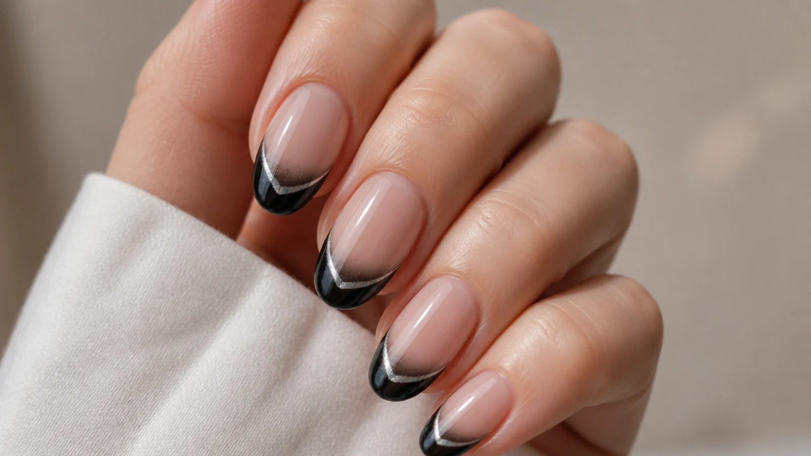 Sheer nude nails with a crisp black cat eye french tip and light stripe