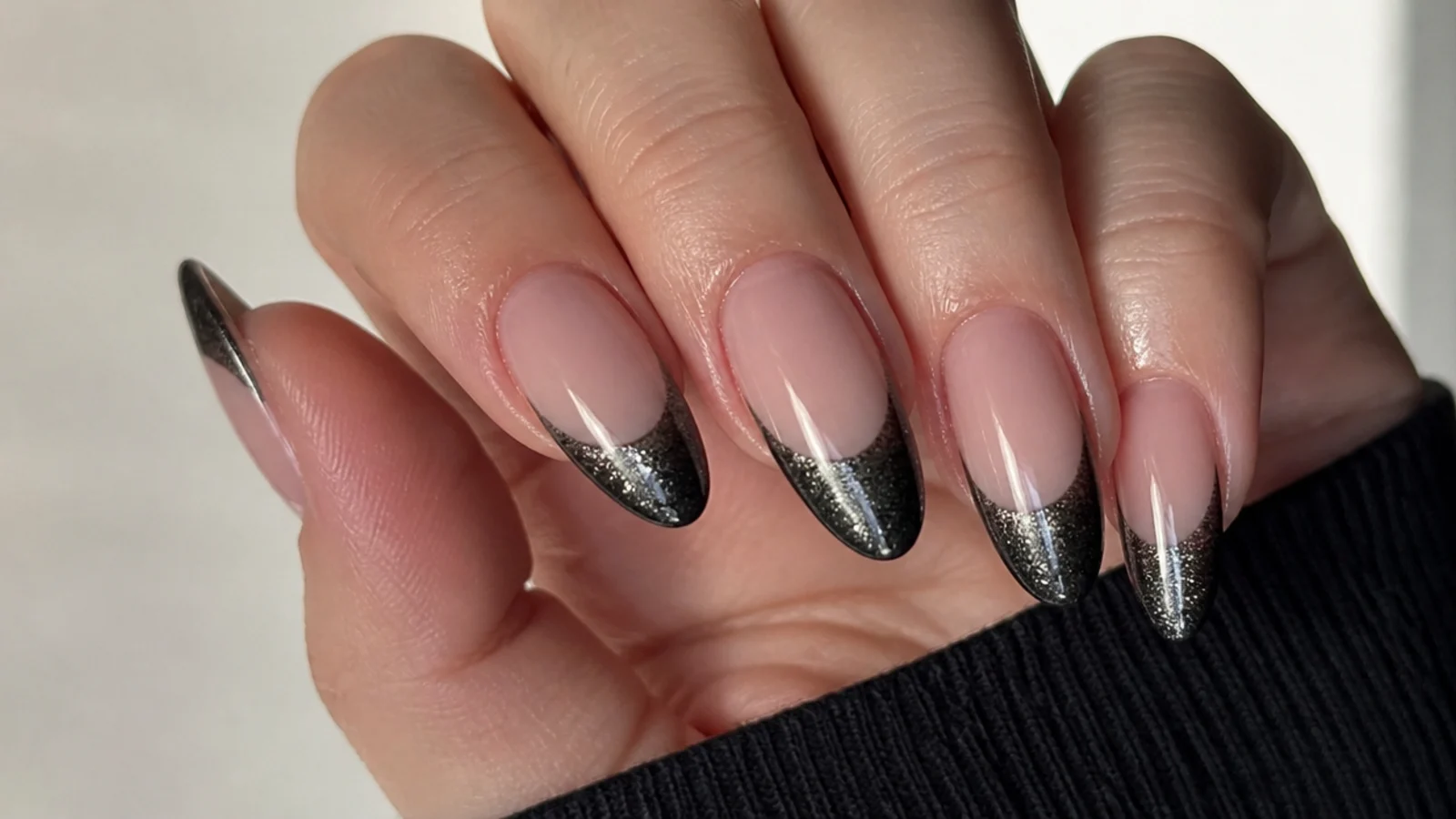 A well-sealed black cat eye french manicure with cuticle oil for longevity