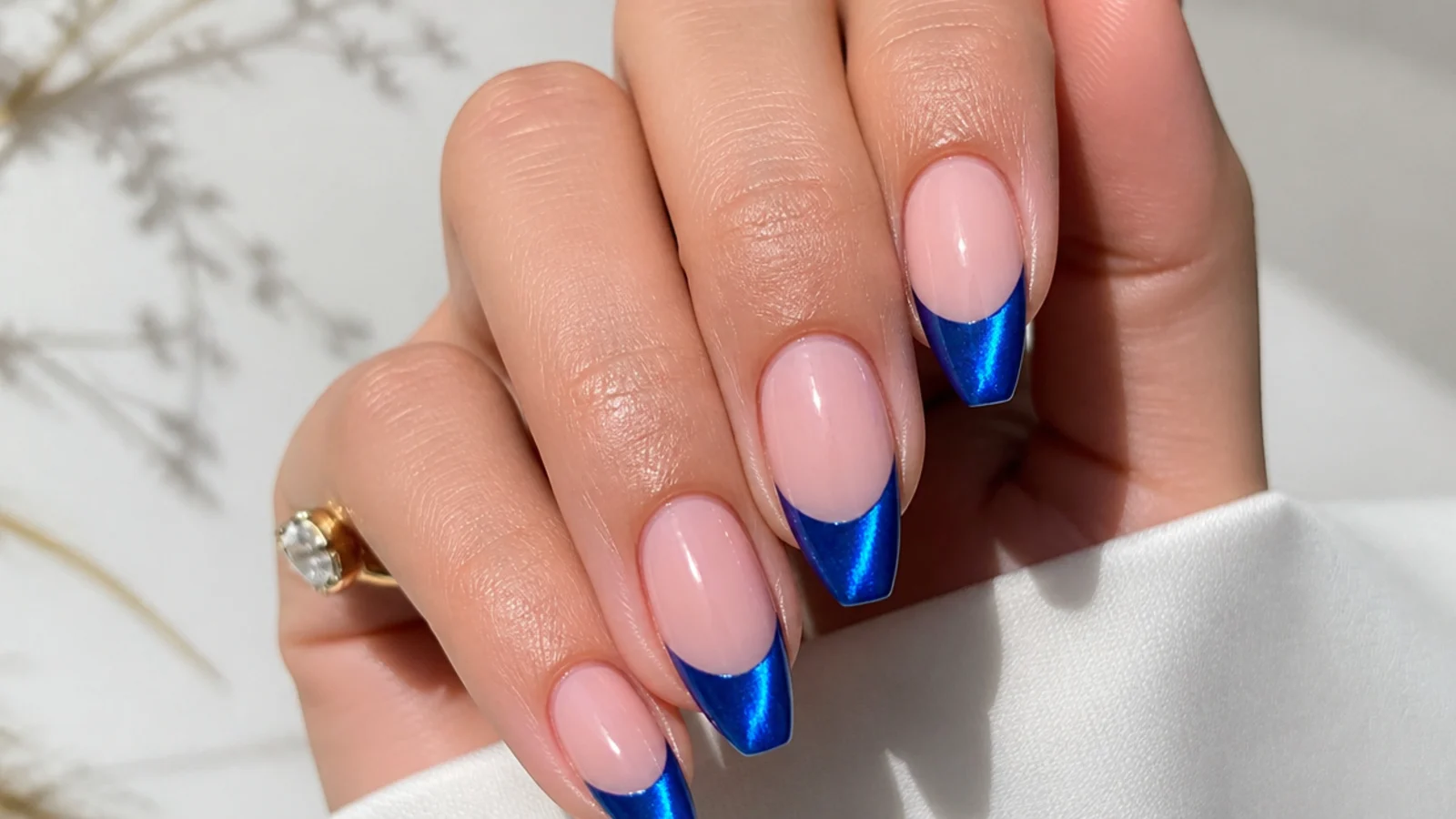 Bright cobalt blue cat eye french tip nails with a vivid center light band