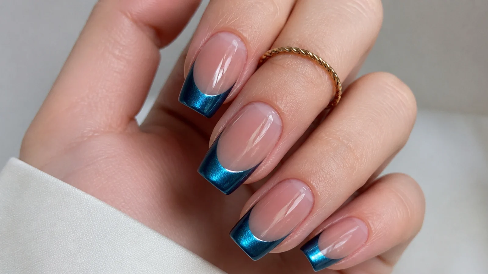 Metallic chrome blue cat eye french tip nails with a mirror-like light stripe