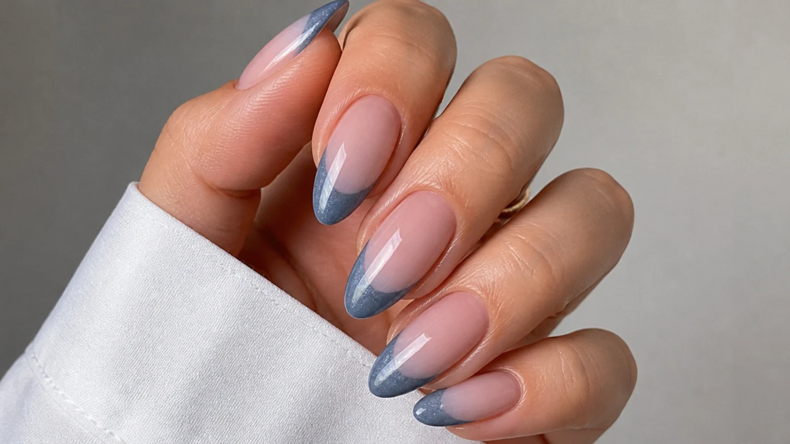 Muted denim blue cat eye french tip nails with a soft gray light stripe