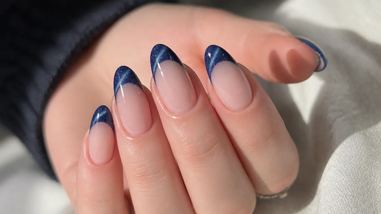 Dark midnight blue cat eye french tips with fine glitter and a bright stripe