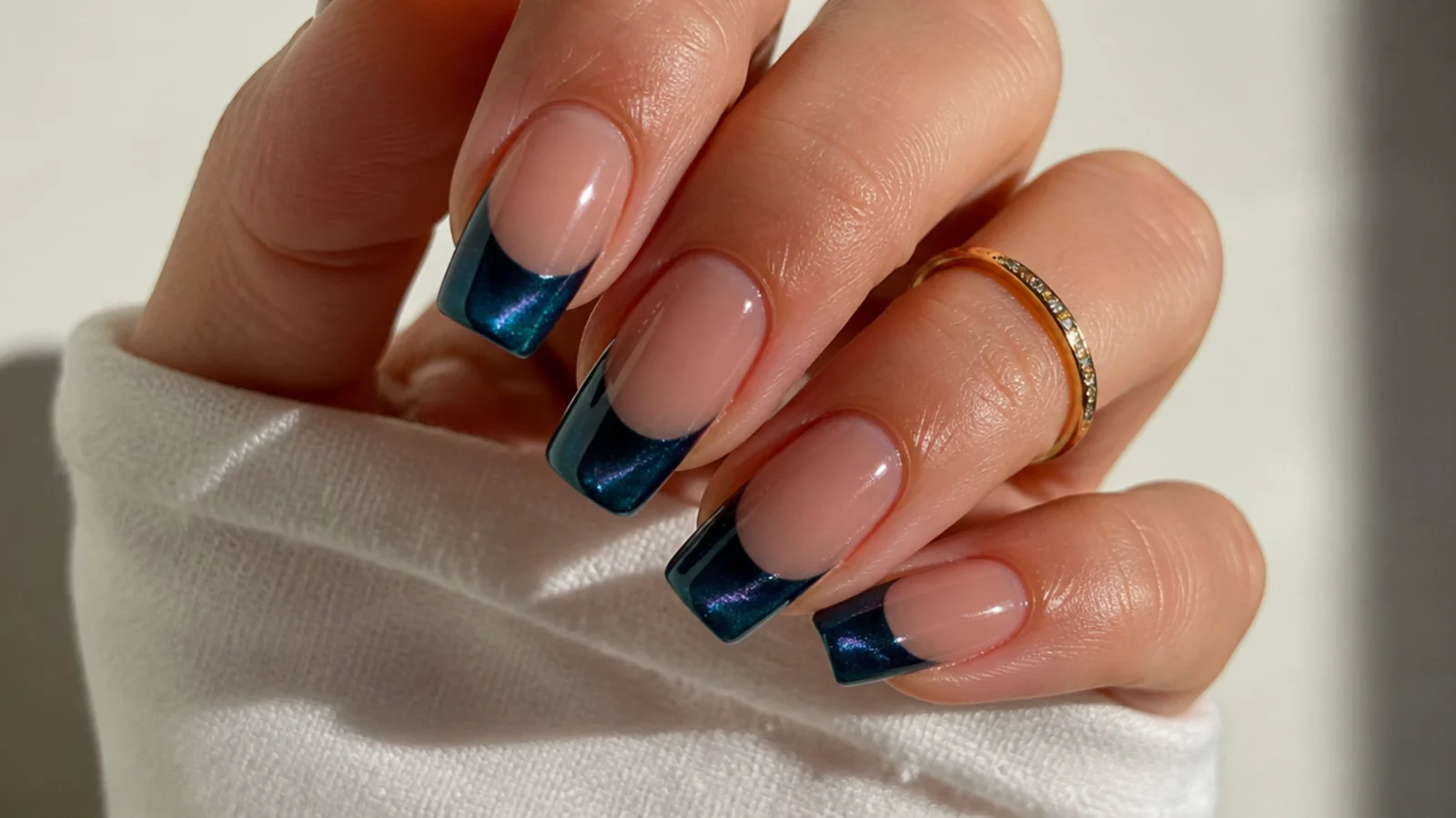 Deep peacock blue cat eye french tip nails with a jewel-toned shifting stripe
