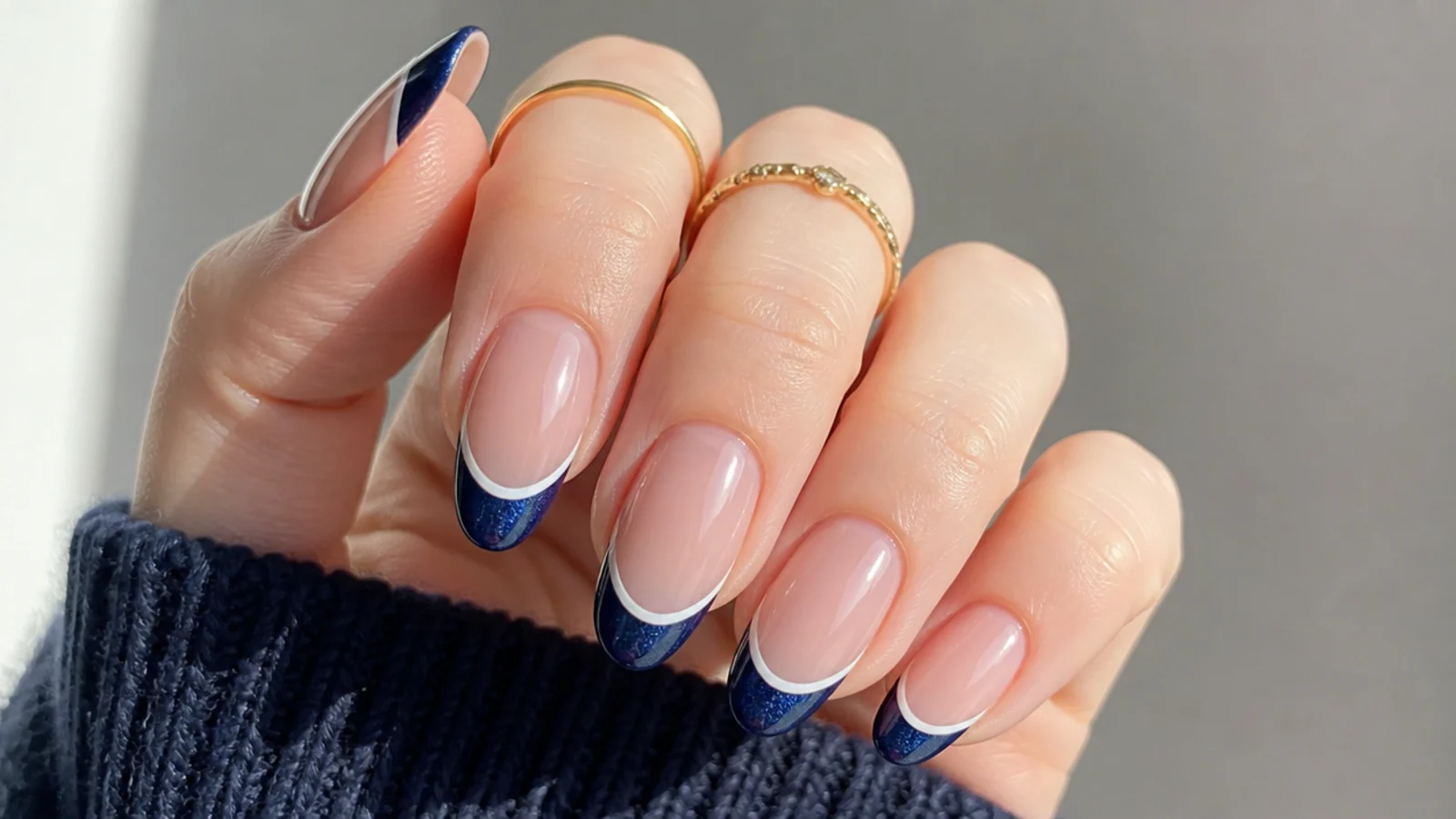 Navy cat eye french tip with a thin white line above it on almond nails