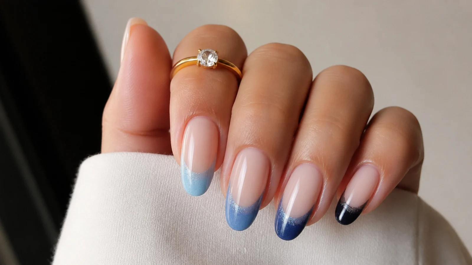 Cat eye french tips fading from light blue to navy across the hand