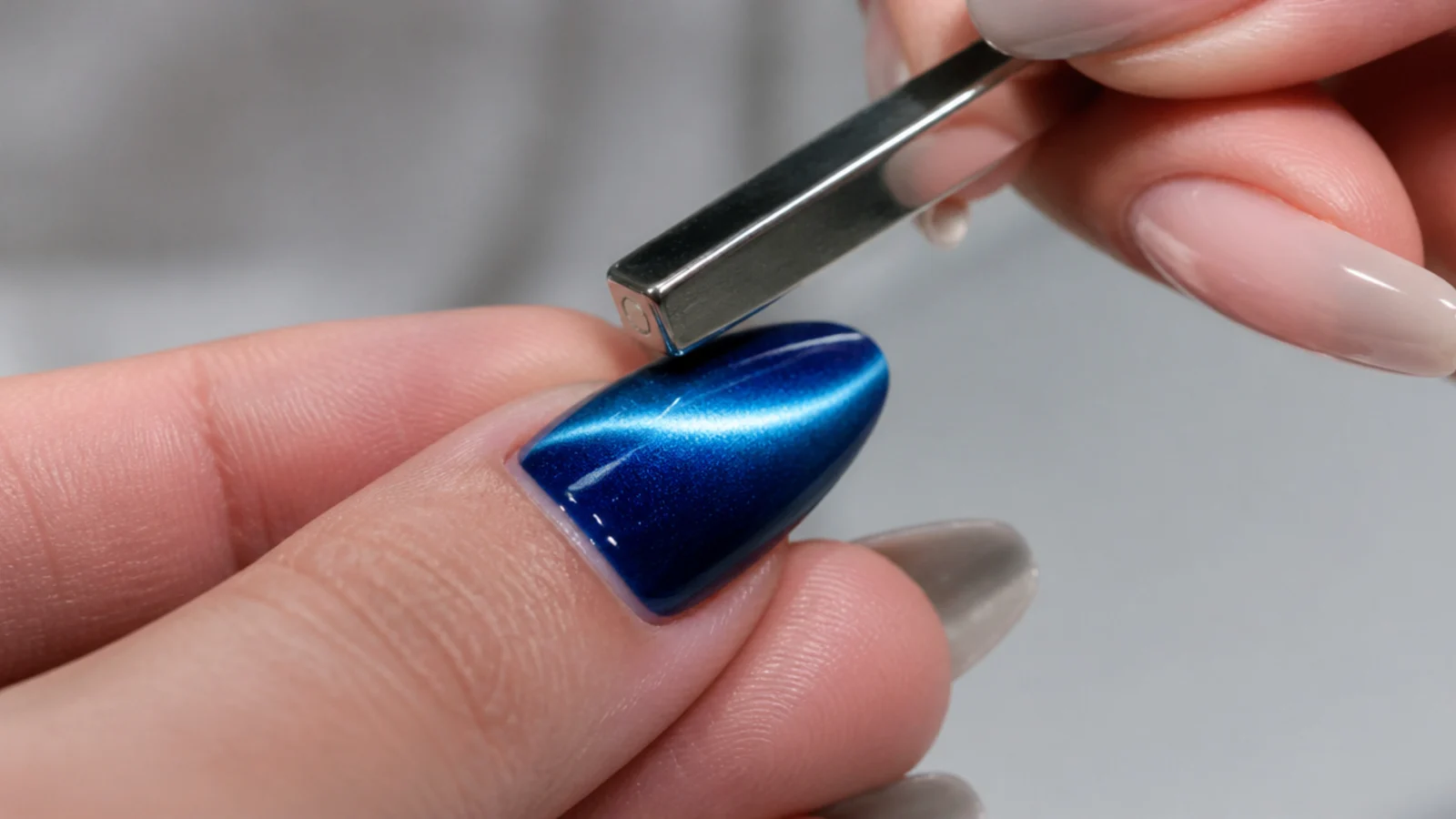 A magnet held above a wet blue gel tip pulling a bright light stripe