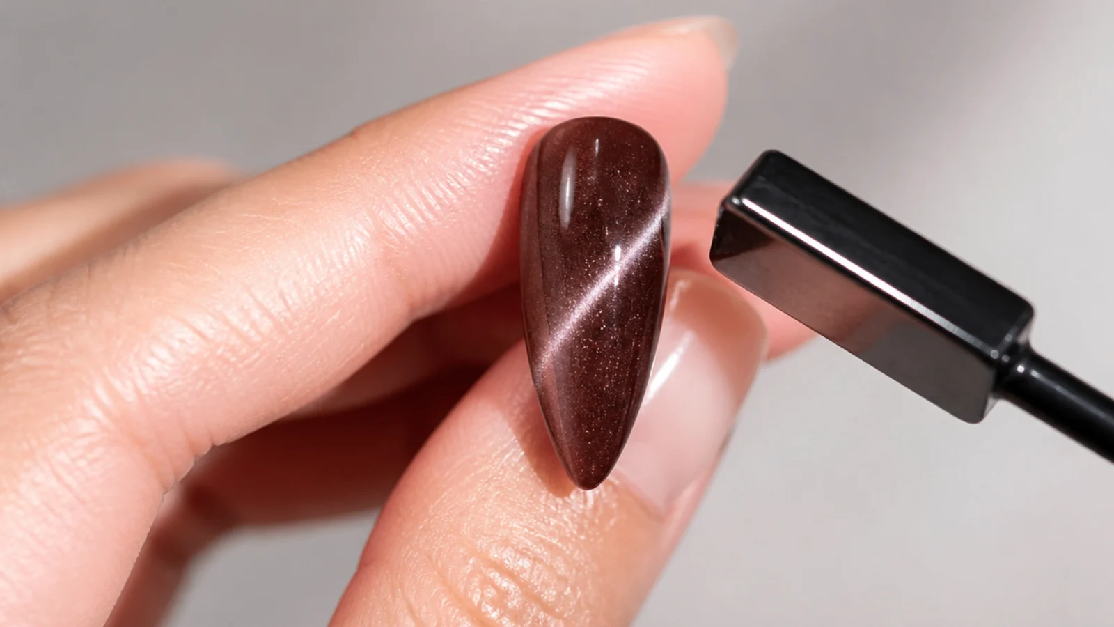 A magnet hovering over a wet brown magnetic gel tip pulling a light stripe