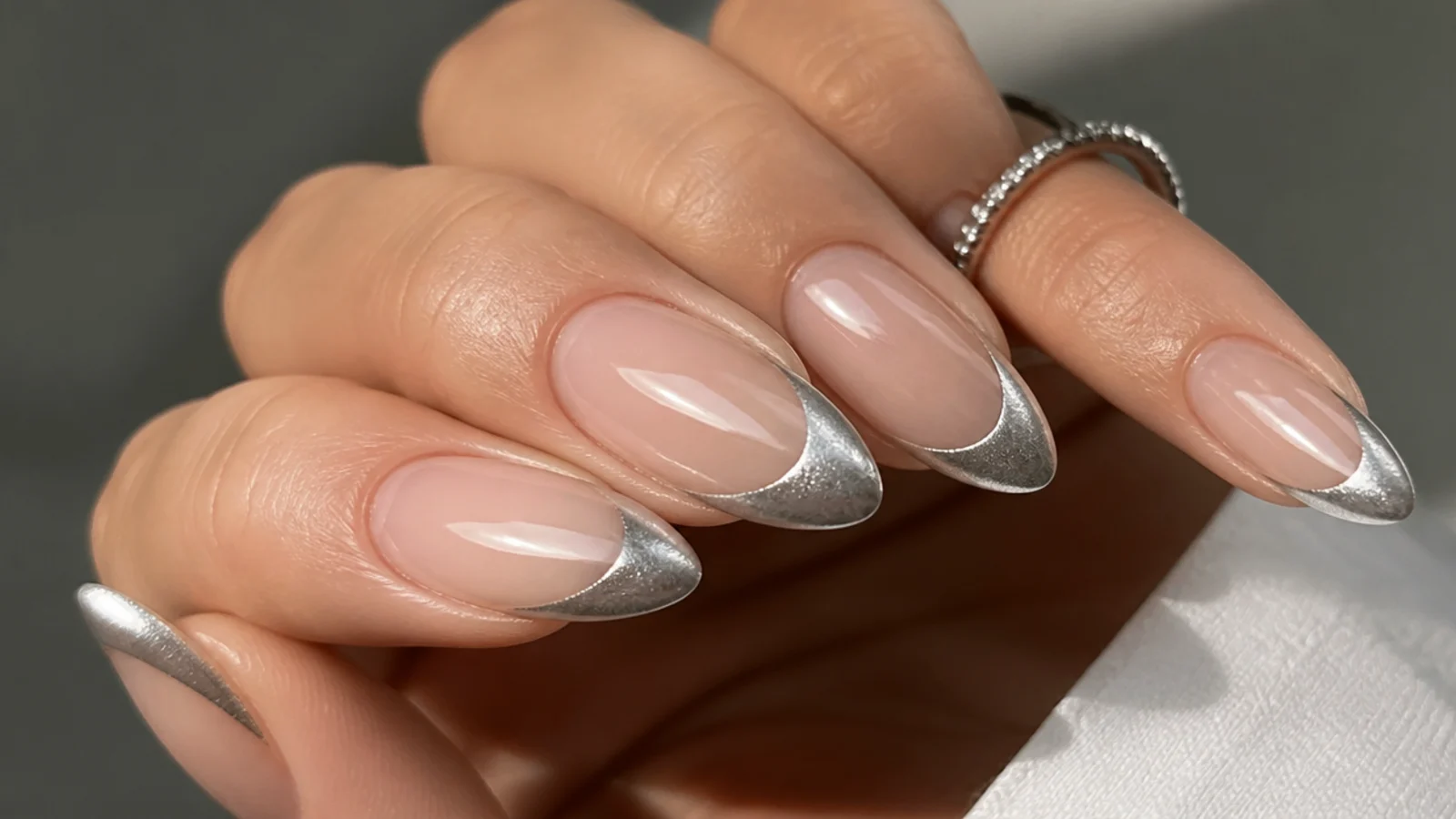 Nude nails with a mirror-like liquid silver magnetic cat eye french tip