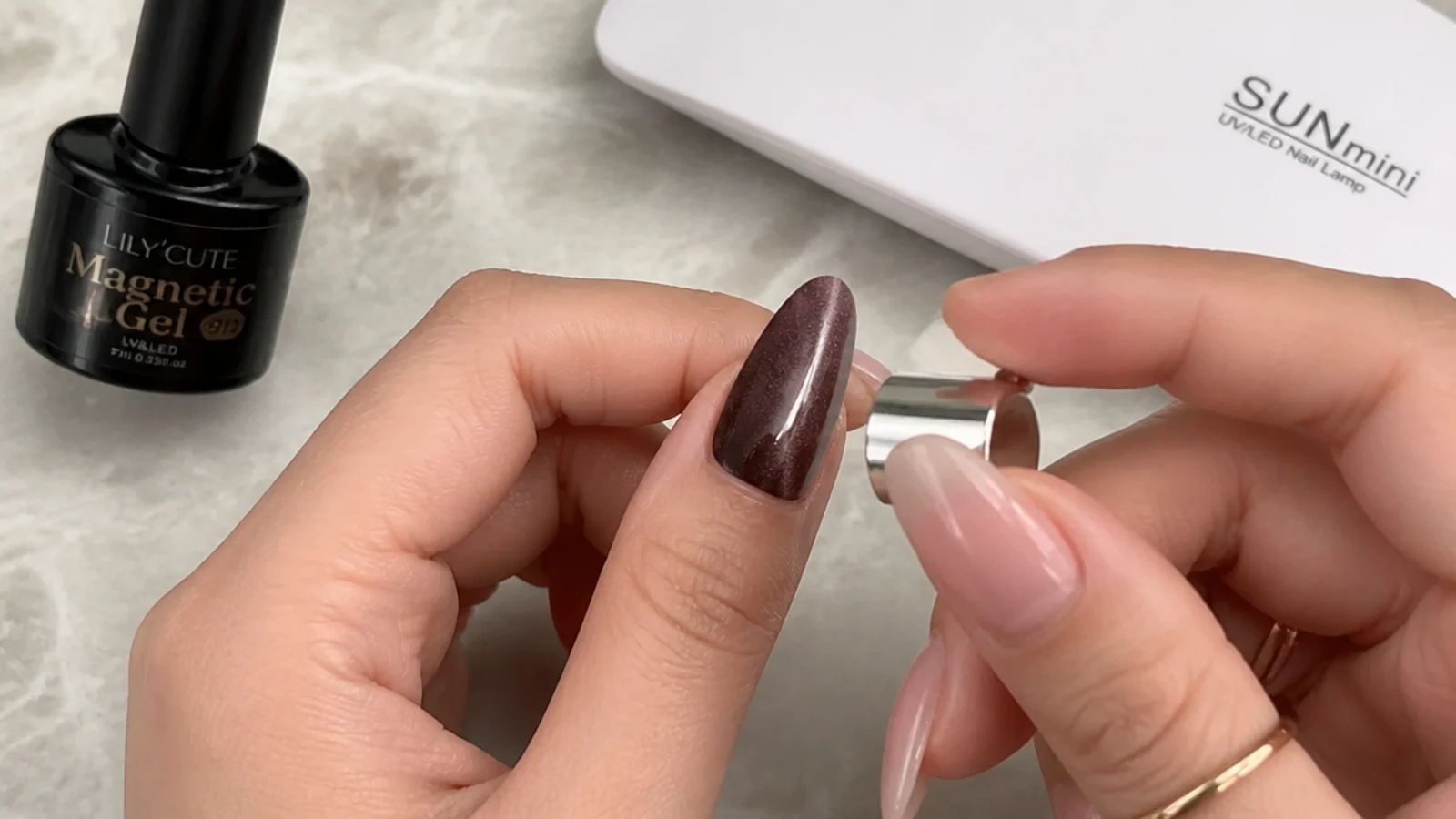 Home setup with magnetic gel, a cap magnet and an LED lamp beside a nail mid-stripe