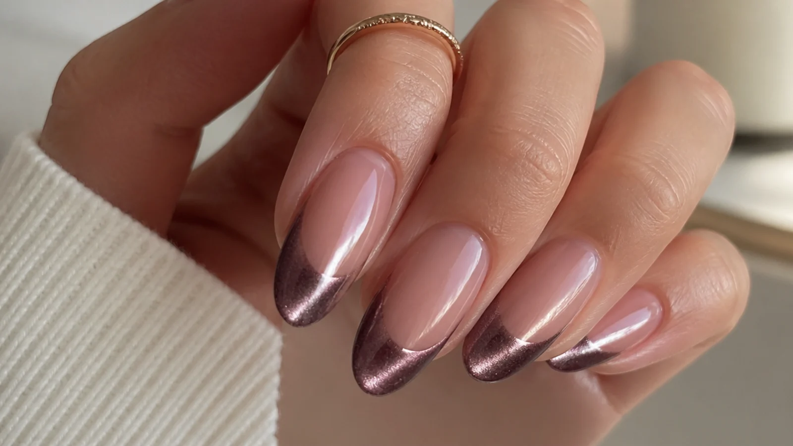 Almond nails with a magnetic cat eye french tip catching a bright stripe of light